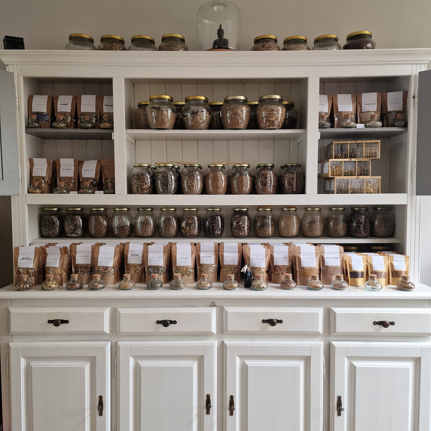 Theemelanges in potten en zakken in theekast van Our World Within